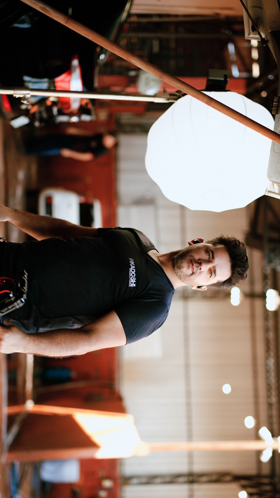 Profissional da Kadoshi em um set de gravação, ao lado de equipamentos de iluminação
